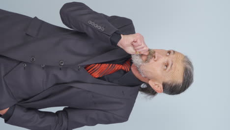 Vertical-video-of-Stressed-old-businessman-biting-nails.